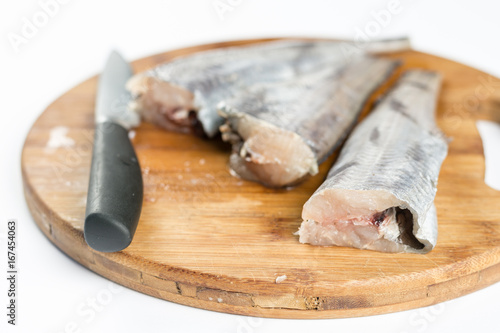 Fresh sliced raw hake fish on the cuting board