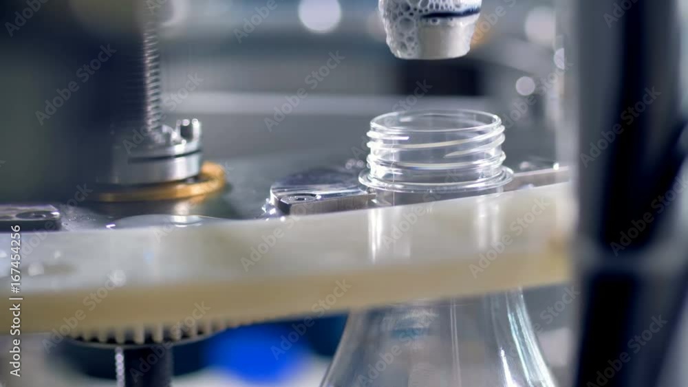 A close-up view on a working milk-filling valve. A close-up view on a working milk-filling valve.
