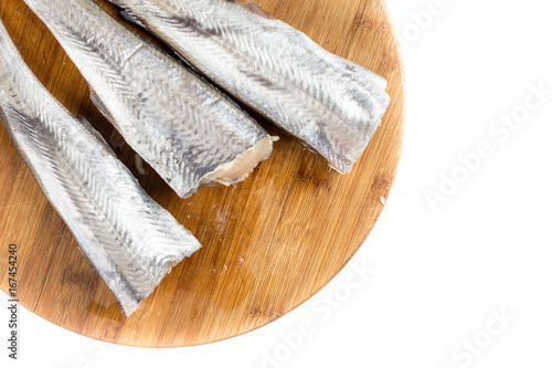 Flat lay above fresh raw hake fish on the wooden board with copy space