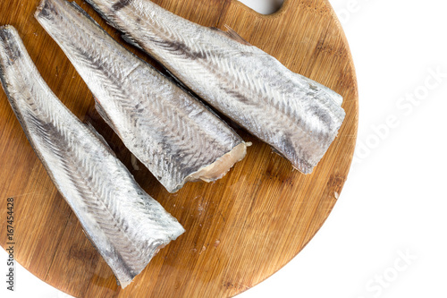 Flat lay hake fish on the wooden board with white background copy space
