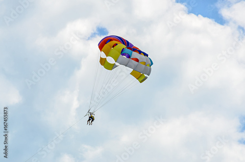 Colored parasail wing in the blue clouds sky, Parasailing also known as parascending or parakiting