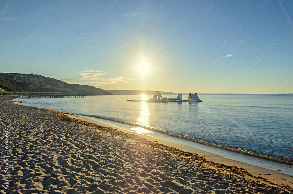 Beach of Black Sea from Albena, Bulgaria with golden sands, blue clear  water, yellow sun rays - obrazy, fototapety, plakaty 