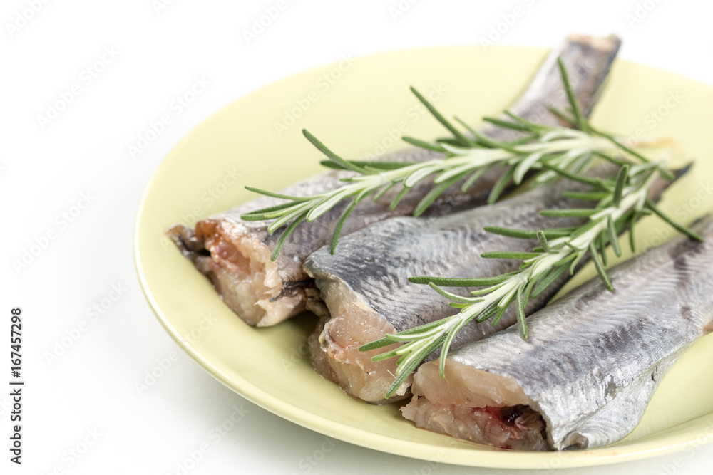 Hake fish on the plate with rosemary branches Hake fish on the plate with rosemary branches