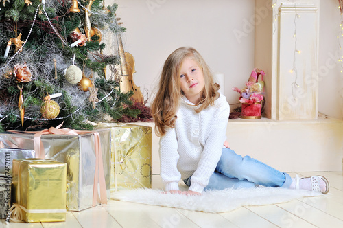 Happy little girl under the Christmas tree.