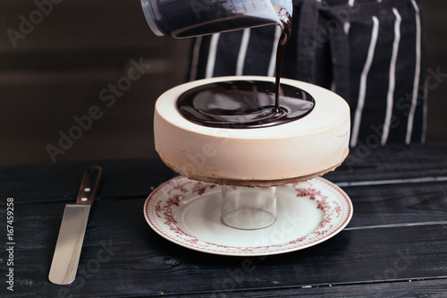 Glazing chocolate mousse cake, close-up photo