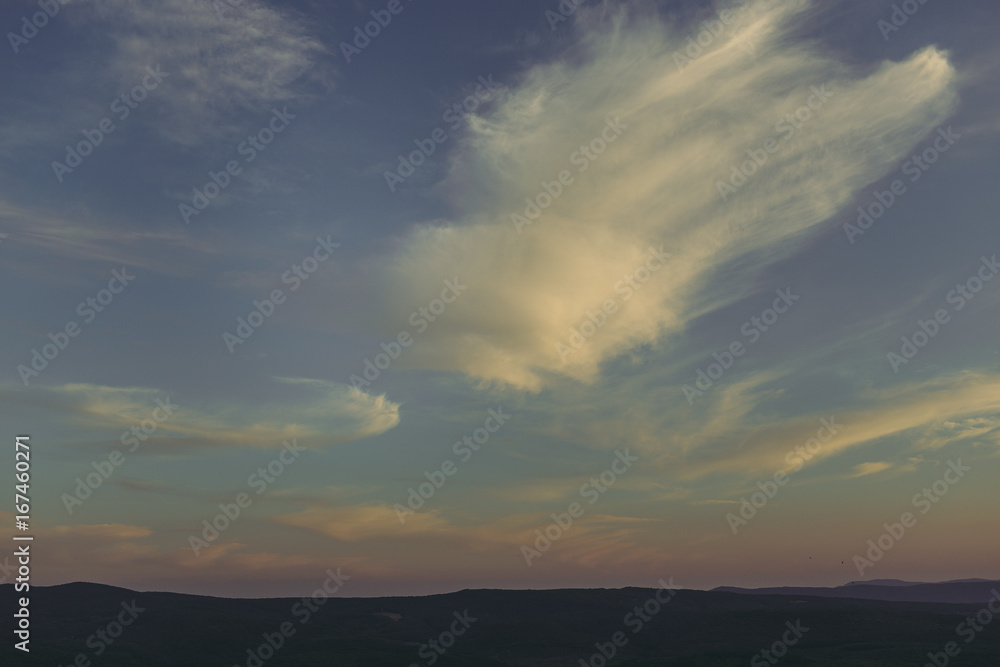 Sky. Beautiful clouds over the valley. Landscape. Background with cloudy sky. Incredible view. Patterns from the clouds. Evening.