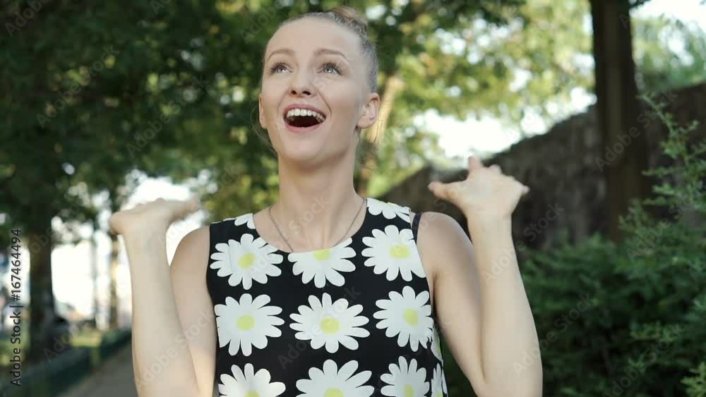 Pretty girl looks excited and joyful while standing in the park, steadycam shot
Pretty girl looks excited and joyful while standing in the park, steadycam shot