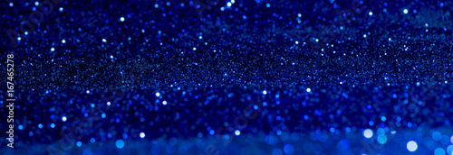 blue Sparkling Lights Festive background with texture. Abstract Christmas twinkled bright bokeh defocused and Falling stars. Winter Card or invitation.