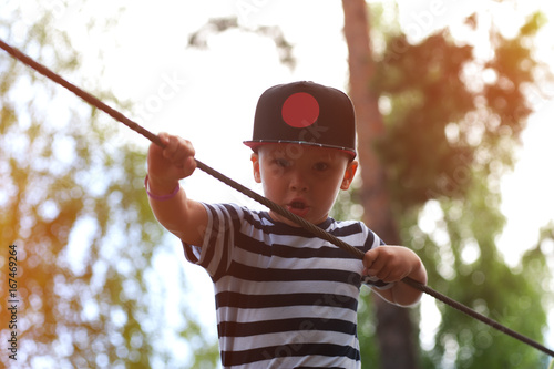 Little boy climbing in extreme parkoutdoors photo