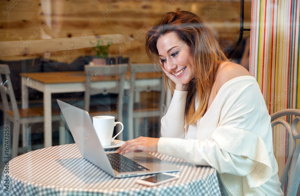 Business woman working with laptop and mobile phone at cafe, freelance concept Business woman working with laptop and mobile phone at cafe, freelance concept
