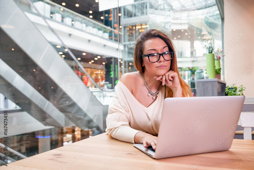 Business woman with laptop working at open space office in modern interior Business woman with laptop working at open space office in modern interior