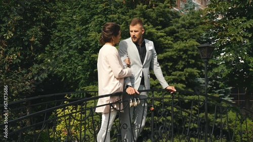 young beautiful couple walking in the Park and stands on the bridge photo