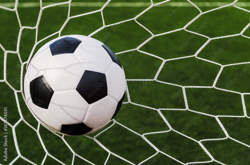 Soccer football in Goal net with green grass field. Soccer football in Goal net with green grass field.