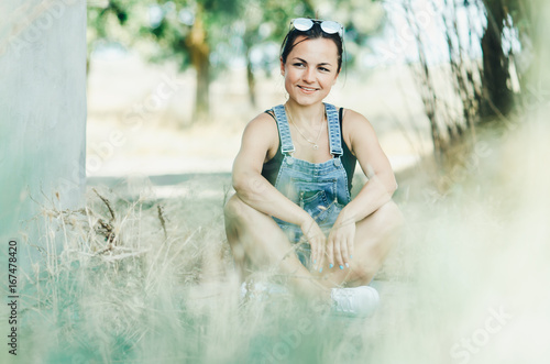 The girl on the grass in overalls