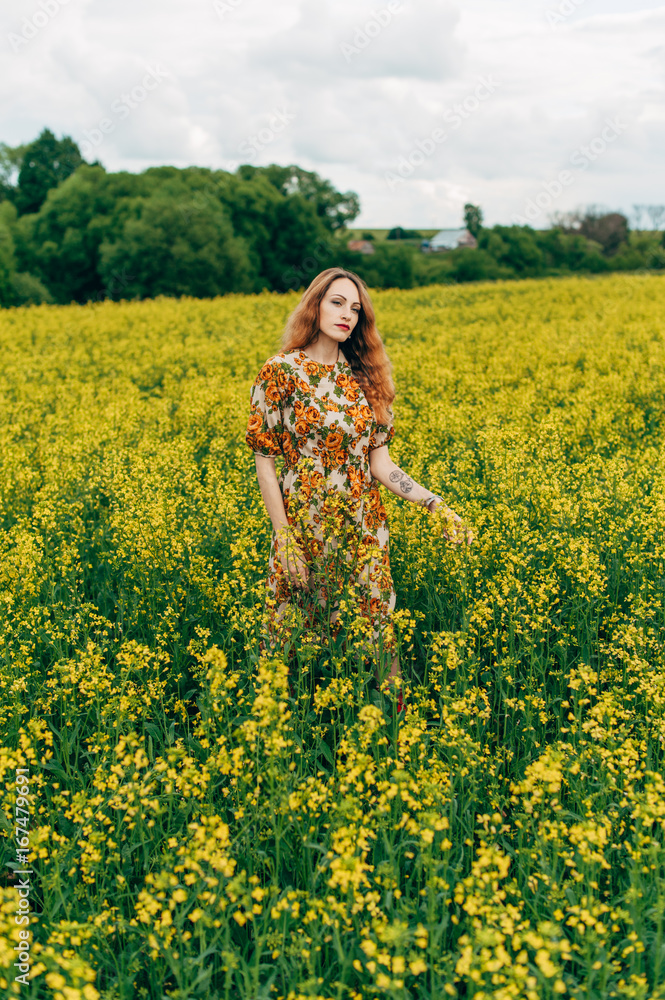 Beautiful girl in a dress among yellow flowers in a field Beautiful girl in a dress among yellow flowers in a field