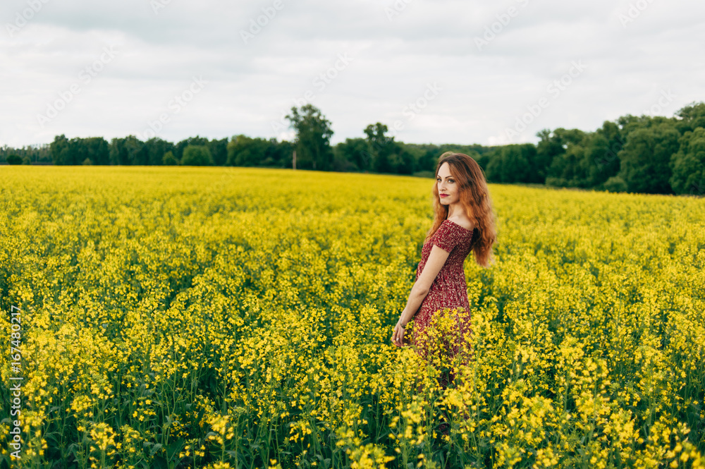 Beautiful girl in a dress among yellow flowers in a field Beautiful girl in a dress among yellow flowers in a field