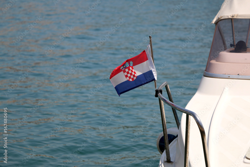 Small Croatian flag on a boat, blowing in the wind. Selective focus. 
