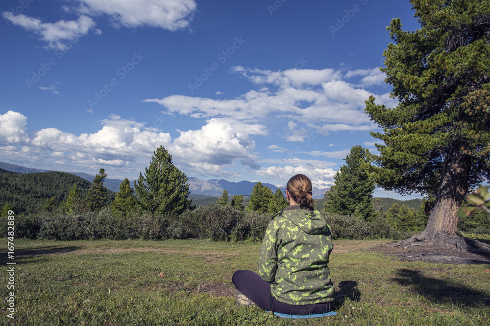 The girl on the nature in the forest looks into the distance. The girl on the nature in the forest looks into the distance.