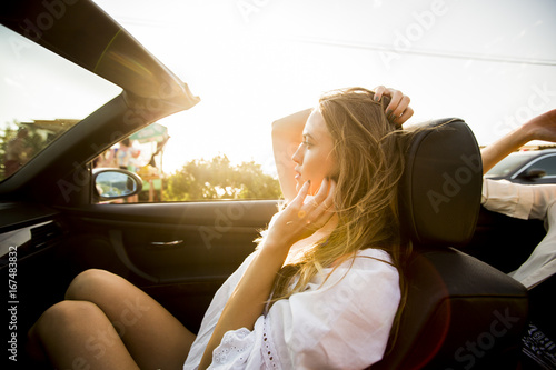 Woman uses mobile phone and siting in cabriolet at summer day © BGStock72
