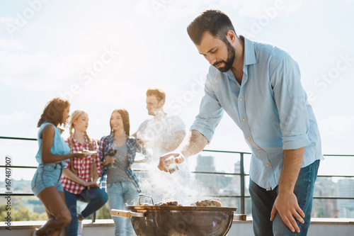 Group of friends having barbecue party on the roof