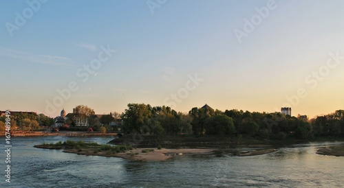 Sunset on river Loire and Saint Martin basilica of Tours in the background, Loire Valley - UNESCO world heritage, France