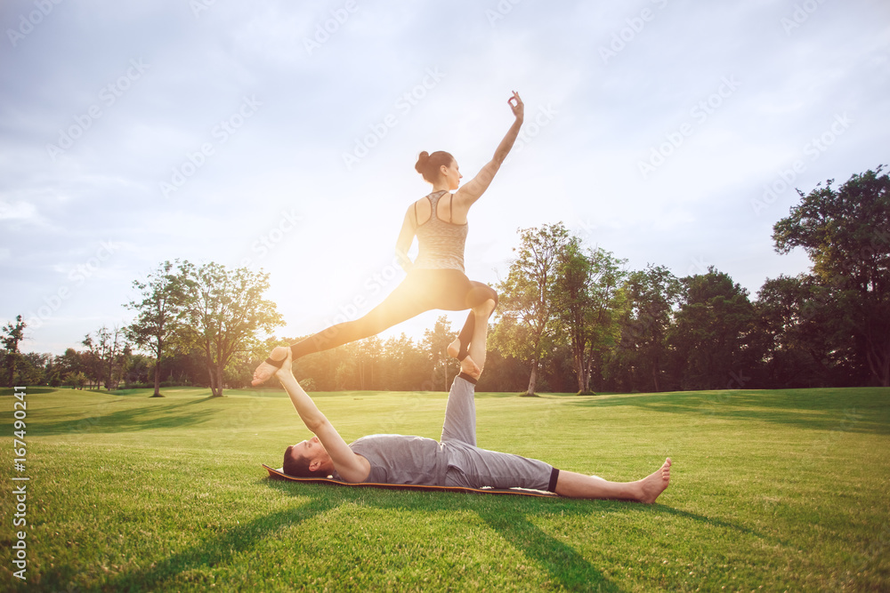 Fototapeta premium People practice acro yoga outdoors healthy lifestyle