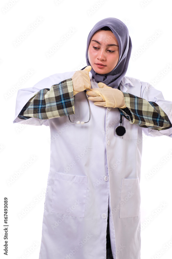 Portrait of an attractive beautiful female doctor in a white coat wearing the surgical gloves Portrait of an attractive beautiful female doctor in a white coat wearing the surgical gloves
