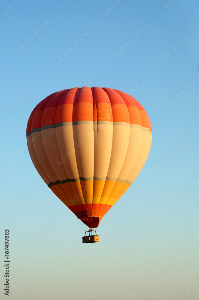 Fototapeta premium ballooning. Bright multicolored balloon against the blue sky