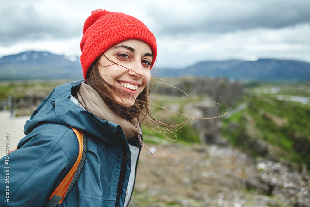 Naklejka premium Girl in warm clothing observing surroundings on background of mountains of Iceland.