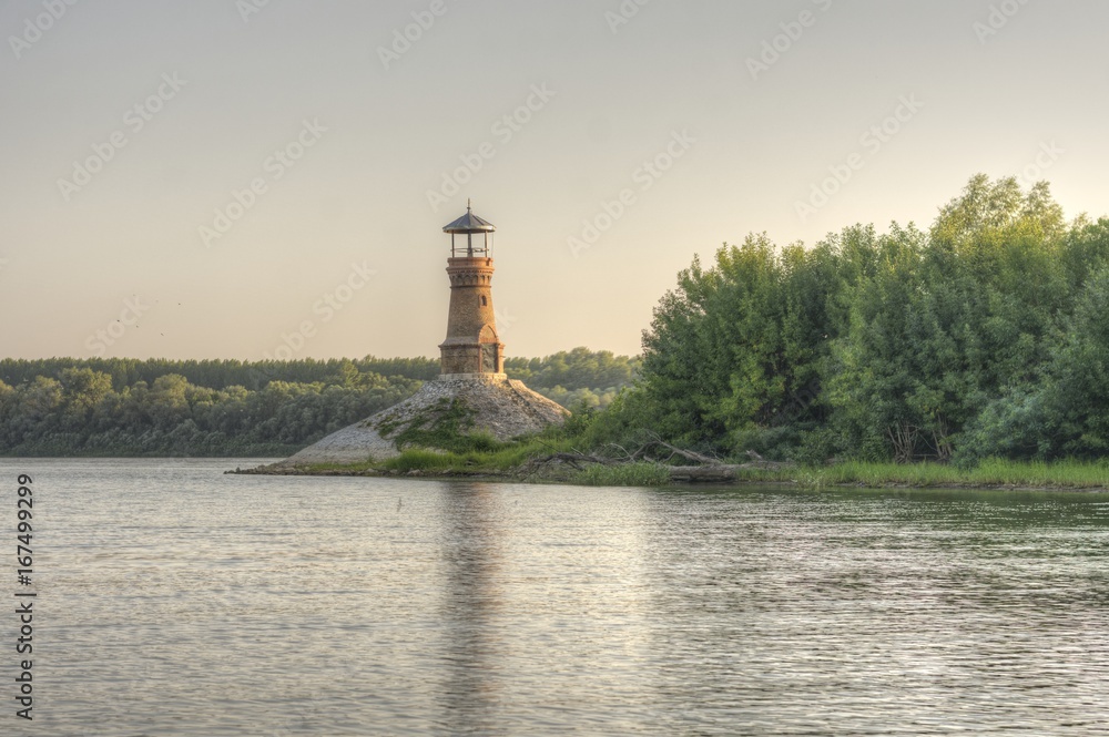 Old brick lighthouse on the river with clear sky