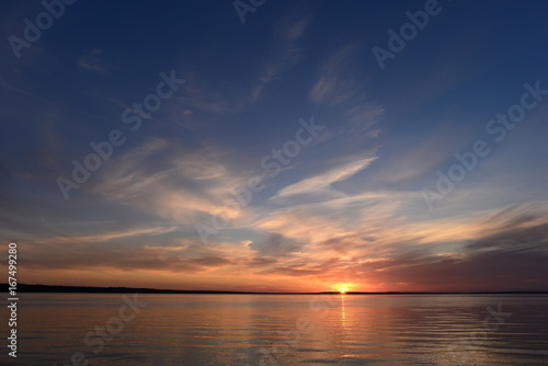 Fototapeta Naklejka Na Ścianę i Meble -  Sunset in the clear blue summer sky above the lake