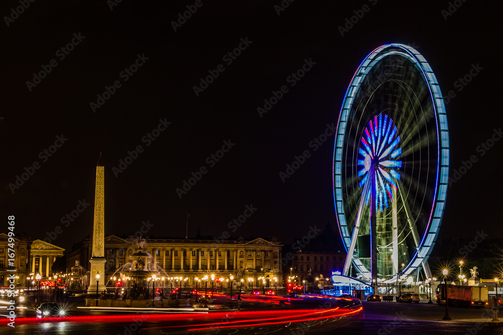 night in Paris with cars and ferris wheel spinning with car light trails