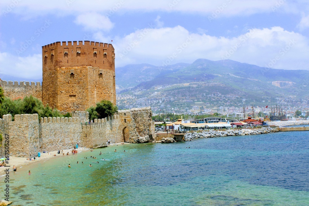 View of Red Tower and fortress wall from the old shipyard (Alanya, Turkey).