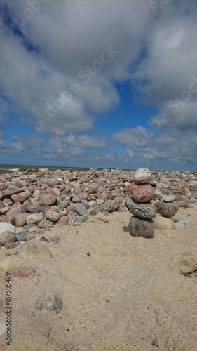 Cloudy beautiful sky over beach with stones