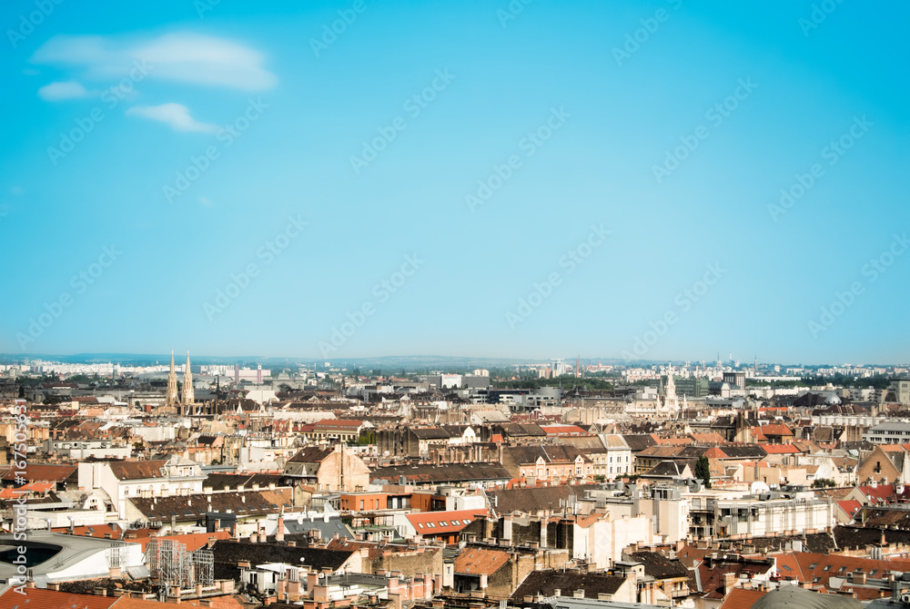 Beautiful panoramic aerial view over the roofs of Budapest, old orange tile roofs of buildings and churches on sunny summer day, Hungary. Copy space for text.