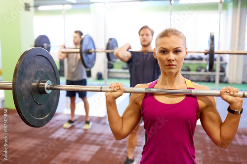 group of people training with barbells in gym