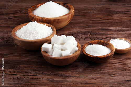 Sugar composition with white sugar in bowls on wooden board