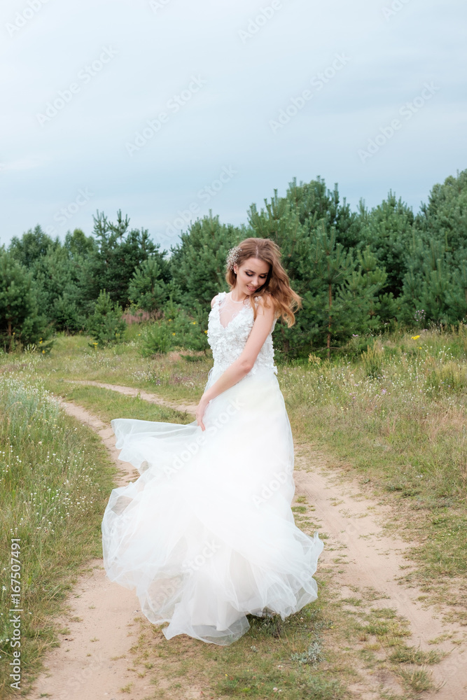 young pretty woman (bride) in white wedding dress outdoors, make up and hairstyle