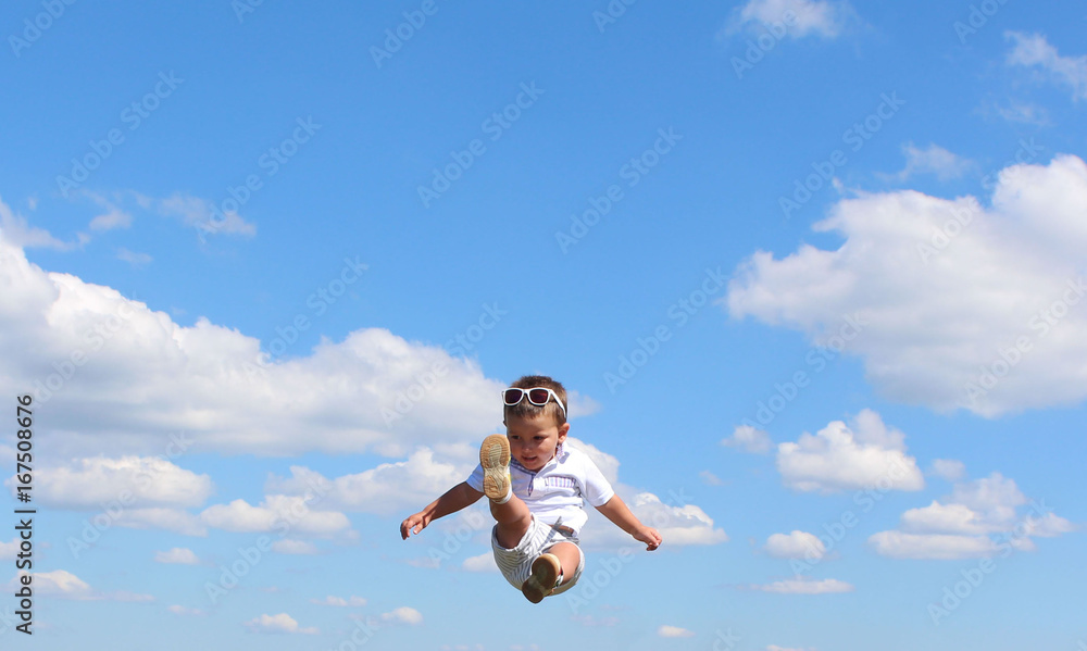 Portrait of cute happy kid small boy in the sky. Child having fun and enjoying sun in the panorama park. concept of flight. Trampolining. Portrait of cute happy kid small boy in the sky. Child having fun and enjoying sun in the panorama park. concept of flight. Trampolining.