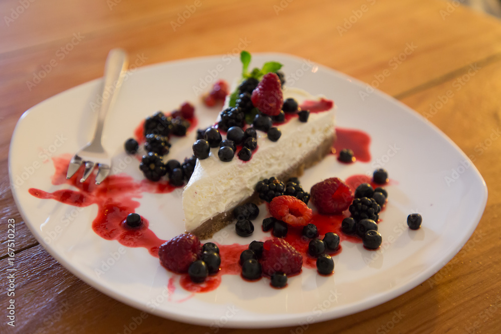 Berry cheesecake with berries on a plate in a caffe Berry cheesecake with berries on a plate in a caffe