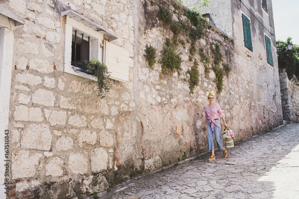 Woman walking on footpath by wall Woman walking on footpath by wall