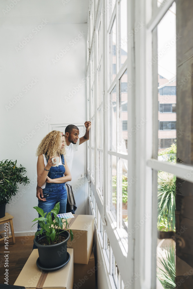 Couple looking through window while standing in new house