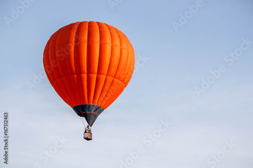 bright orange balloon flying in the blue sky