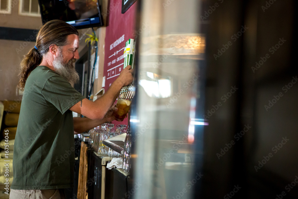 Side view of man pouring beer from tap Side view of man pouring beer from tap