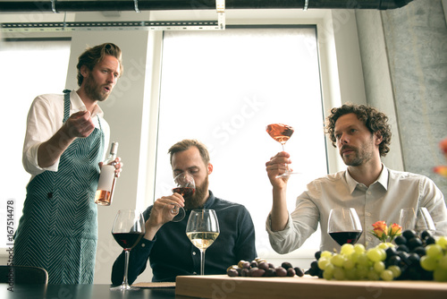 Bartender explaining to customers while tasting wine