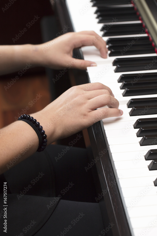 Fototapeta premium Young person playing the piano with both hands