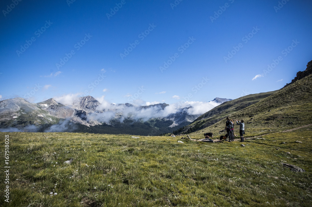 Fototapeta premium Hikers on Field on Brown's Pass in Mountains