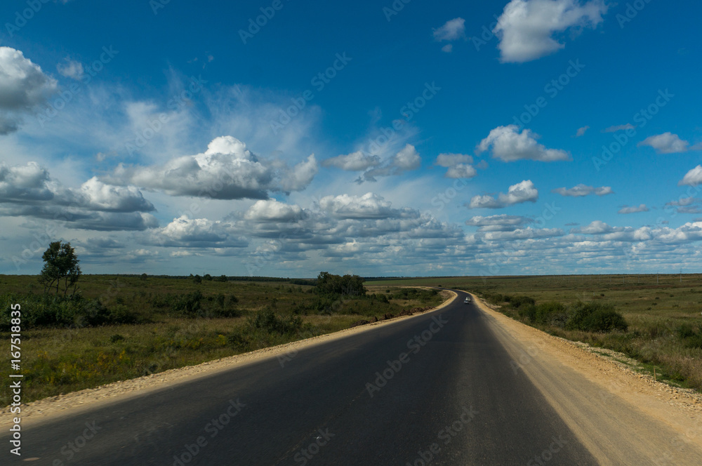 Beautiful clouds and new empty road