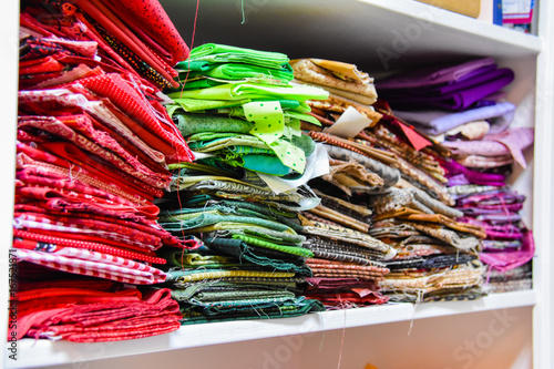 Colorful fabric stacked on the shelf by color