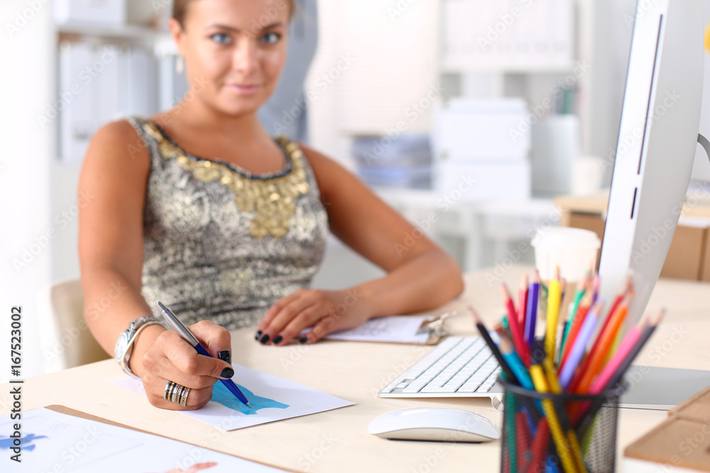 Young woman working in office, sitting at desk with folder Young woman working in office, sitting at desk with folder
